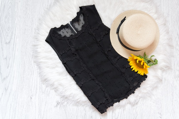 Blusa de encaje negro. Sombrero y girasol en piel blanca.