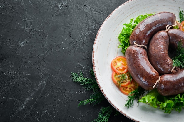 Blutige Wurst in einem Teller mit Tomaten und Salat Draufsicht Freier Platz für Ihren Text