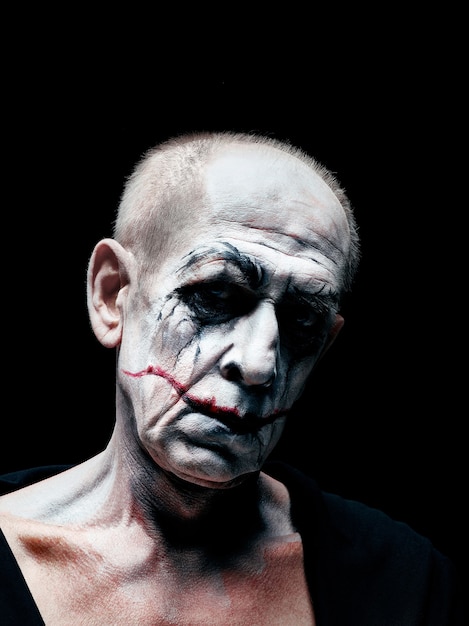 Blutiges Halloween-Thema: Das verrückte Maniak-Gesicht auf dunklem Studiohintergrund