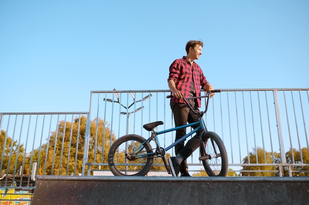 Bmx Biker macht Trick, Teenager beim Training im Skatepark. Extremer Fahrradsport, gefährliche Fahrradübungen, Risikostraßenfahren, Radfahren im Sommerpark