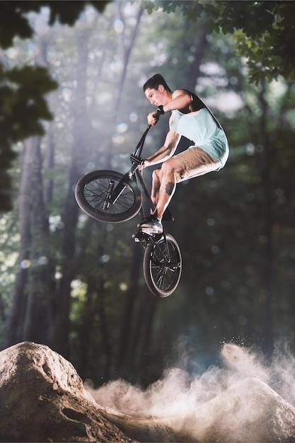 Bmx-Fahrradfahrer, der auf den Waldhügeln austrickst