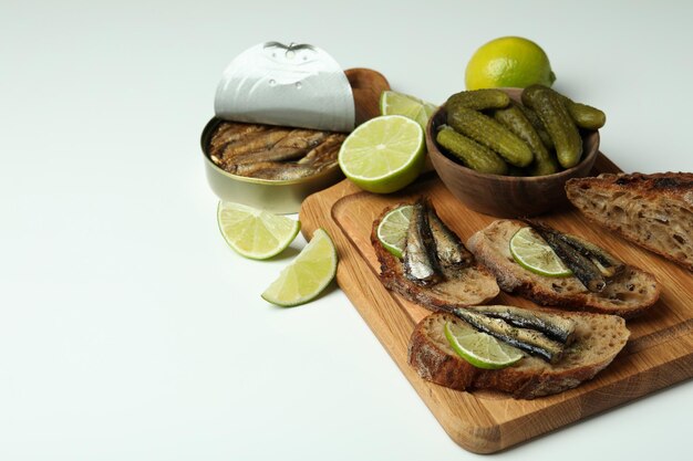 Board mit Sandwiches mit Sprotten auf weißem Hintergrund