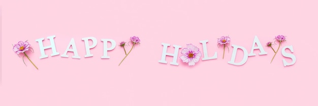 Boas festas. Banner com citação motivacional de letras brancas e flores naturais de beleza em fundo rosa. Citação inspiradora do conceito criativo