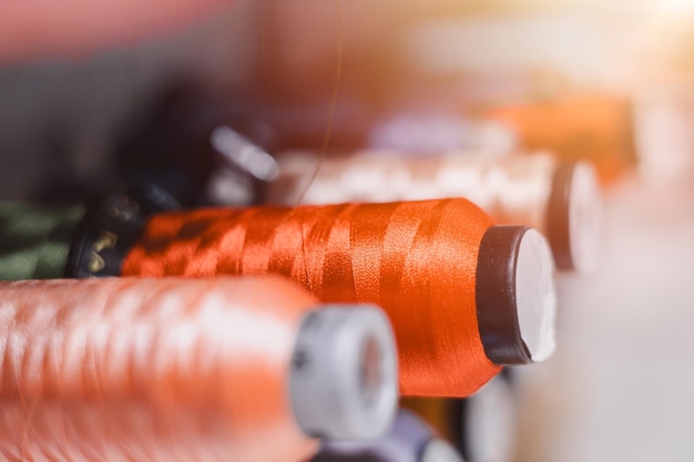 Foto los bobinas de hilo para el tejido en máquinas de coser automáticas en material de ropa industrial de colores de sastre