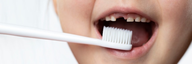 Boca de bebê com orifício para dente de leite e escova de dentes. Escovar os dentes, contar os dentes.