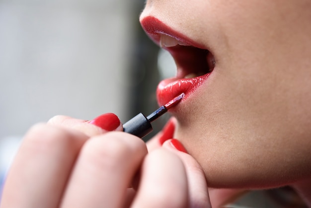 Boca de la mujer atractiva con maquillaje de labios rojos de moda