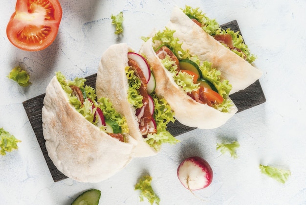 Bocadillo. Comida para llevar, comida rápida en la calle. Sandwich de pan de pita con verduras frescas lechuga, pepino, tomate, rábano, carne de res