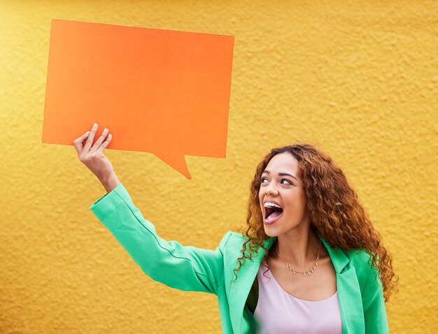 Bocadillo de diálogo de las redes sociales y comunicación con una mujer negra en una pared amarilla para un anuncio Revisión de maquetas y publicidad con una persona africana con un cartel o aviso para marketing