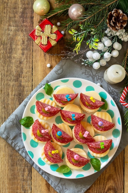 Bocadillo festivo de canapés en la mesa de Navidad Canapés con pan, queso, salami Vista superior