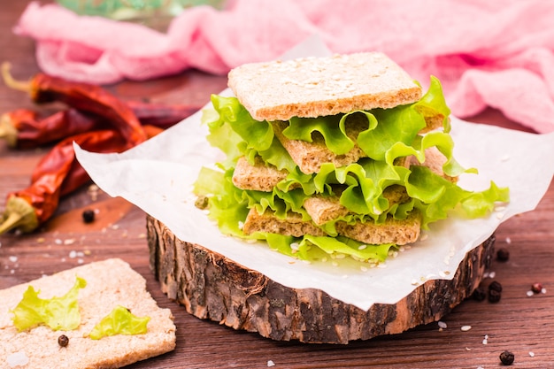 Un bocadillo de pan de cereal, hojas de lechuga y semillas de sésamo.