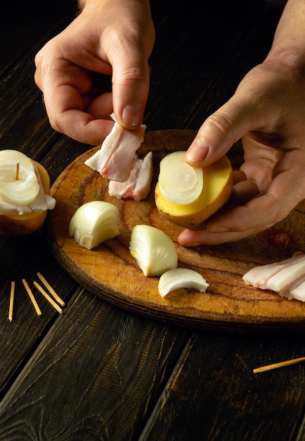 Un bocadillo rápido y fácil llamado vela Cocinar patatas con manteca de cerdo y cebollas a mano antes de asar en la parrilla Espacio publicitario