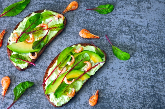 bocadillos abiertos con aguacate y camarones.