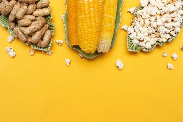 Bocadillos brasileños de junio como palomitas de maíz y maíz en un fondo amarillo