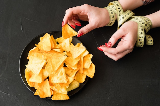 Bocadillos de comida rápida poco saludables malos hábitos de nutrición mujer rompiendo su dieta comiendo papas fritas