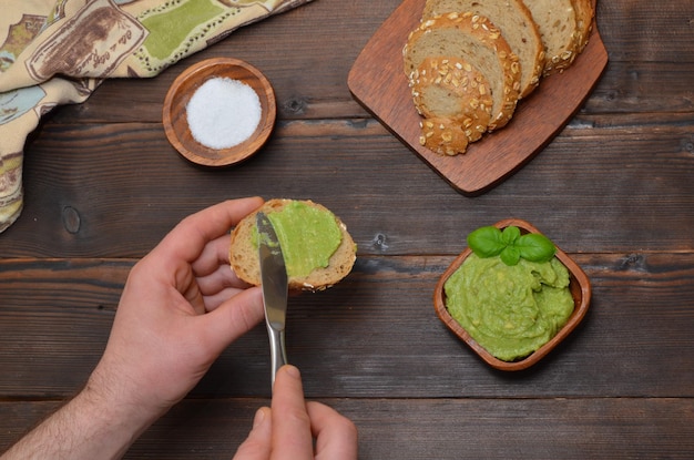 Bocadillos con guacamole y manos masculinas