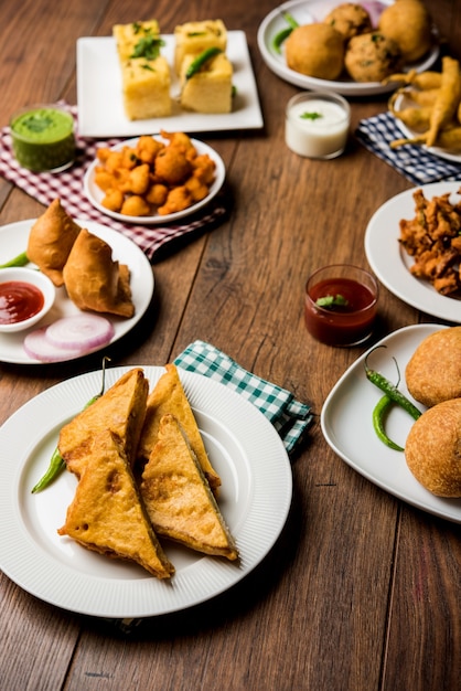 Los bocadillos de la hora del té indio en grupo incluyen Veg Samosa, Kachori, kachaudi, aloo bonda, khaman dhokla, pan, cebolla, chile y moong pakora, pakoda, bhaji, bhajji, Bhajiya, bajji con salsas