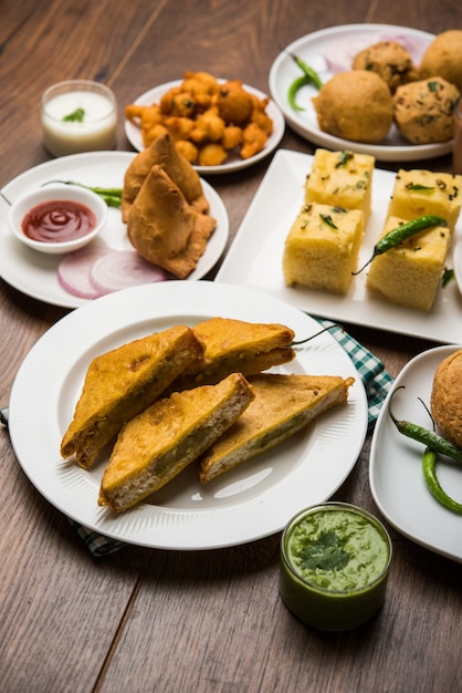 Los bocadillos de la hora del té indio en grupo incluyen Veg Samosa, Kachori, kachaudi, aloo bonda, khaman dhokla, pan, cebolla, chile y moong pakora, pakoda, bhaji, bhajji, Bhajiya, bajji con salsas