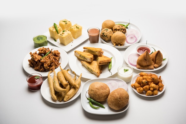 Los bocadillos de la hora del té indio en grupo incluyen Veg Samosa, Kachori, kachaudi, aloo bonda, khaman dhokla, pan, cebolla, chile y moong pakora, pakoda, bhaji, bhajji, Bhajiya, bajji con salsas