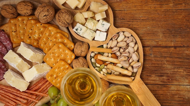 Bocadillos para vino Queso y plato de carne Salchichas queso nueces uvas galletas sobre fondo de madera