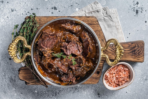 Bochechas de carne assada alemã em molho de vinho tinto marrom Fundo cinza Vista superior