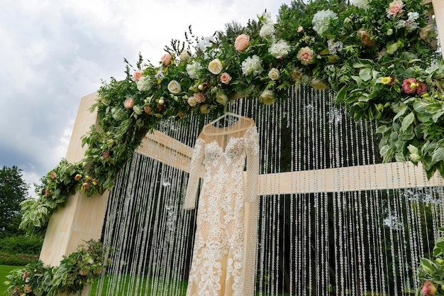 Boda al aire libre de un parque Un hermoso vestido está colgado en el arco de la boda Vista diagonal