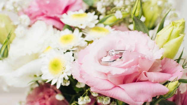 Boda anillos de diamantes en el ramo de flores