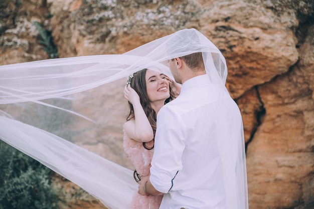 Boda. Boda junto al mar. Pareja joven enamorada, novio barbudo y novia en vestido de novia en el s