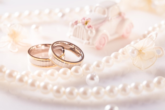 Boda bodegón con anillos de oro y collar de perlas en blanco