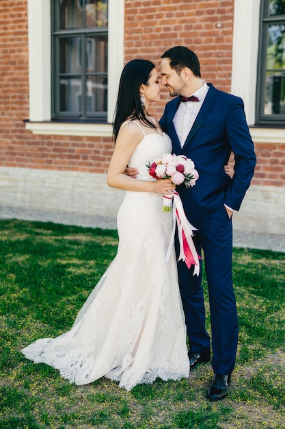 Boda cariñosa joven pareja va a besarse, feliz de celebrar su boda