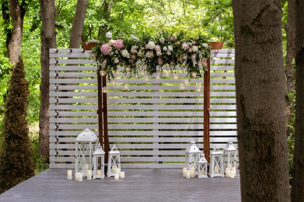 Foto boda ceremonia de boda arco arco decorado con flores blancas de pie en el bosque en el área de la ceremonia de boda día de la boda