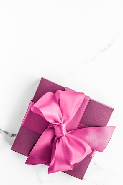 Boda de cumpleaños y concepto de marca femenina Caja de regalo rosa con lazo de seda sobre fondo de mármol Regalo de baby shower para niña y regalo de moda glamour para la marca de belleza de lujo Holiday Flatlay Art Design