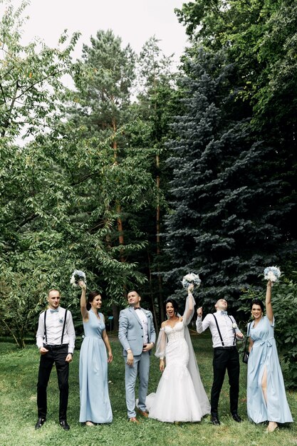 Boda. Día de la boda. Hermosa novia y el novio elegante caminando después de la ceremonia de la boda. Vestido de novia de lujo y ramo de flores. Novia y novio en el día de la boda