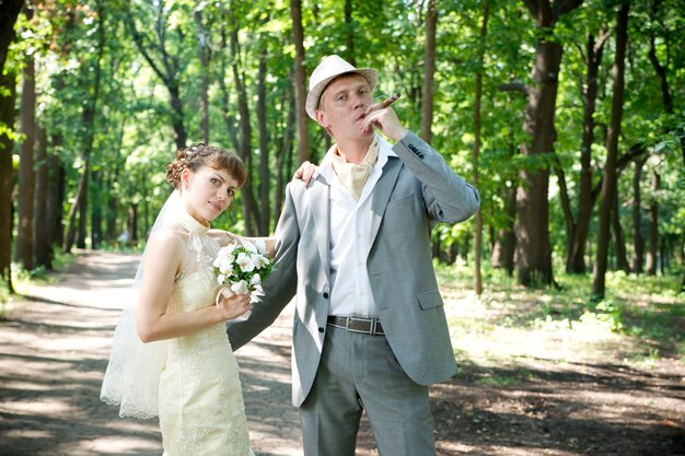 Boda hermosa joven novia y el novio de pie en un parque