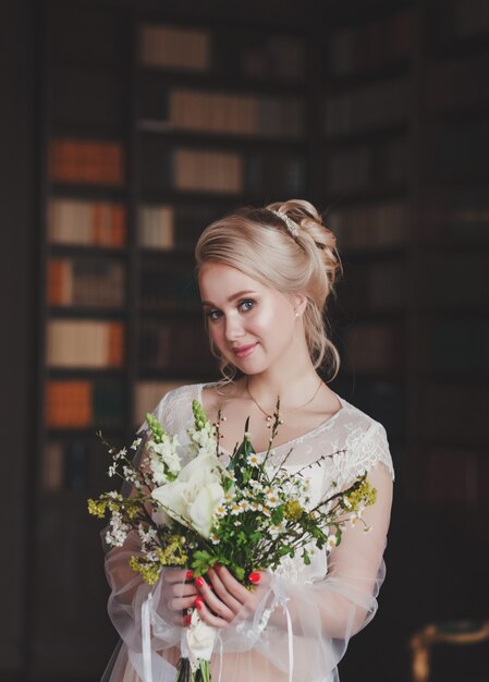 Boda. Hermosa novia adentro con ramo de flores mirando a la cámara