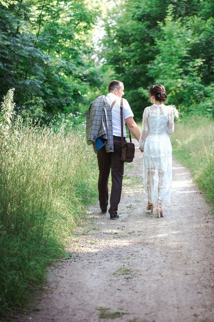 Foto boda de una joven pareja hermosa en estilo vintage. recién casados en un paseo por el parque