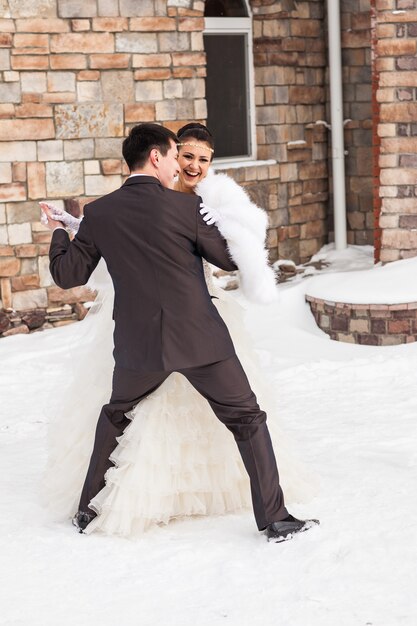 Boda novia y el novio bailando pareja amorosa en el día nupcial de invierno. Disfruta el momento de felicidad.
