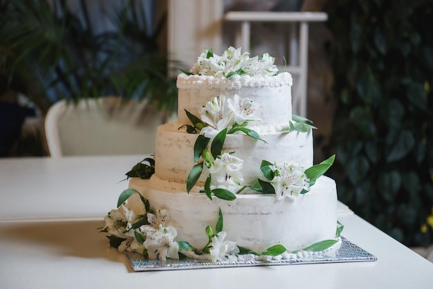 Boda o fiesta de cumpleaños pastel de flores blancas Corte del pastel de bodas para los novios