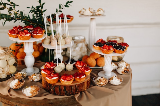 Foto boda de otoño dulce bar. pastel, pastelitos, dulzura y flores.