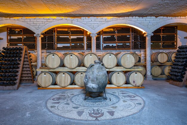 Foto bodega con barriles y botellas.