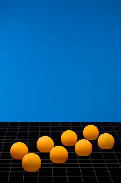 Bodegón abstracto con bolas naranjas sobre un fondo azul.