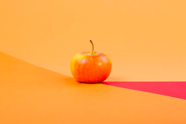 Bodegón abstracto con una manzana sobre un fondo de color