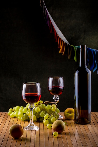 Bodegón con albaricoques, uvas y vino en copas.