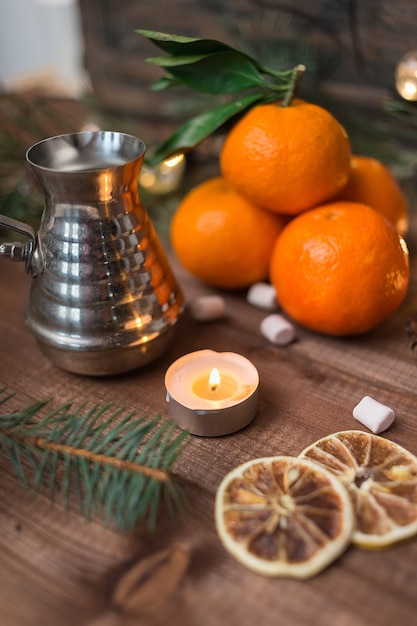 Bodegón de año nuevo con mandarinas frescas, velas encendidas y café turka