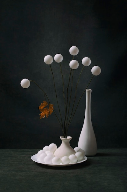 Bodegón con bolas blancas en un jarrón blanco