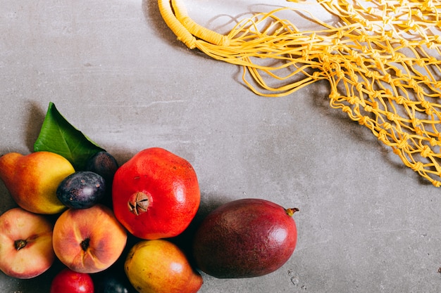 Bodegón de bolsa de compras biodegradable amarilla con fruta cruda