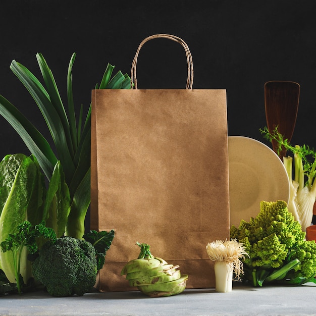 Bodegón bolsa de papel con diferentes alimentos saludables sobre fondo oscuro