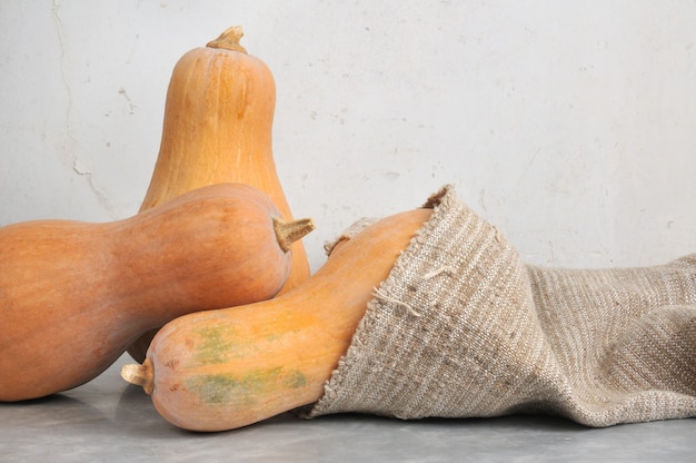 Bodegón de calabazas con luz natural sobre un suelo de mármol en una bolsa.