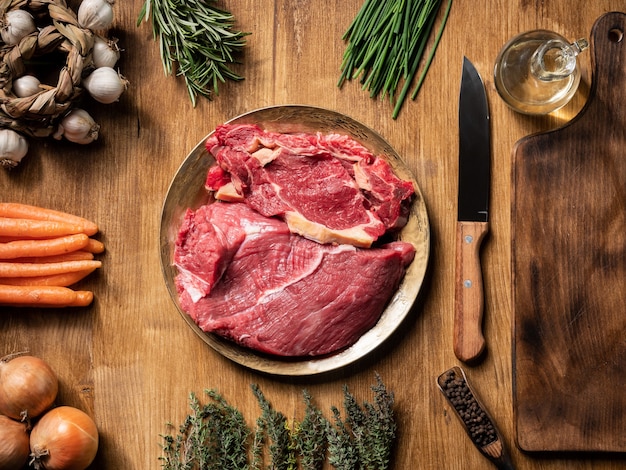 Bodegón de carne cruda con verduras en mesa de madera. Vegetales verdes. Frijoles de pimienta.