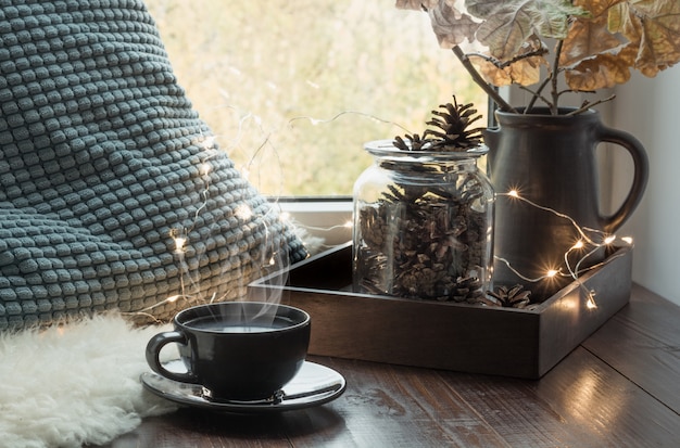 Bodegón en casa interior. Acogedor otoño o invierno. Acogedora taza de café de invierno u otoño en casa caliente piel mullida, guirnalda, concepto de higiene sueco.