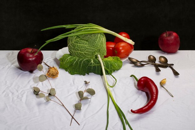 Bodegón con col de Saboya verduras y frutas sobre un mantel blanco